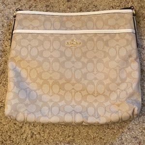 Cream coach bag with strap.
